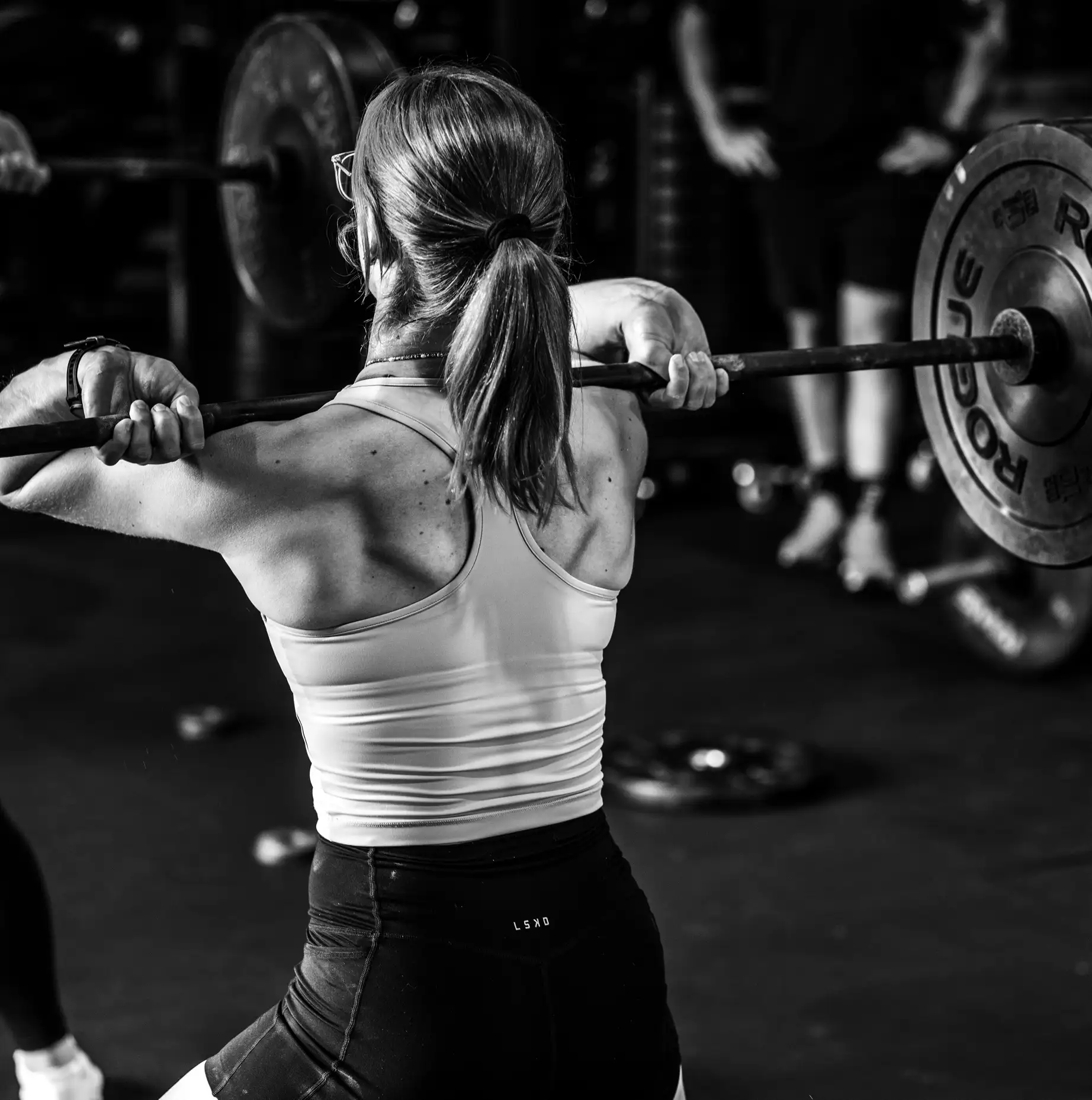 A CrossFit Ulladulla athlete lifting a barbell under coach supervision
