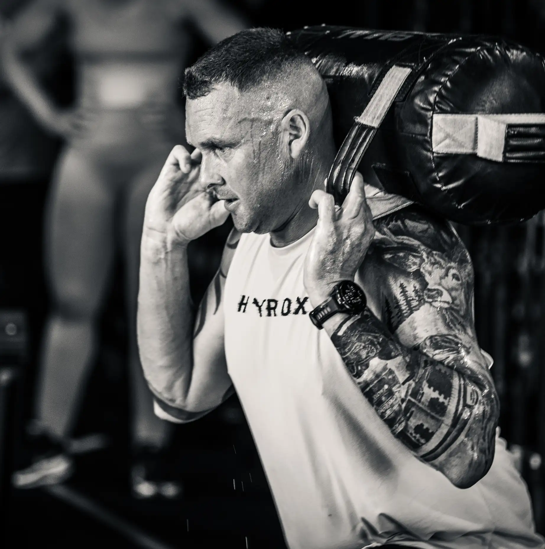 An athlete pushing a weighted sled during a Hyrox training session